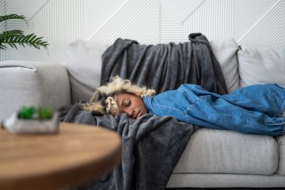 Müde und erschöpfte Frau mit Burn Out auf dem Sofa liegend